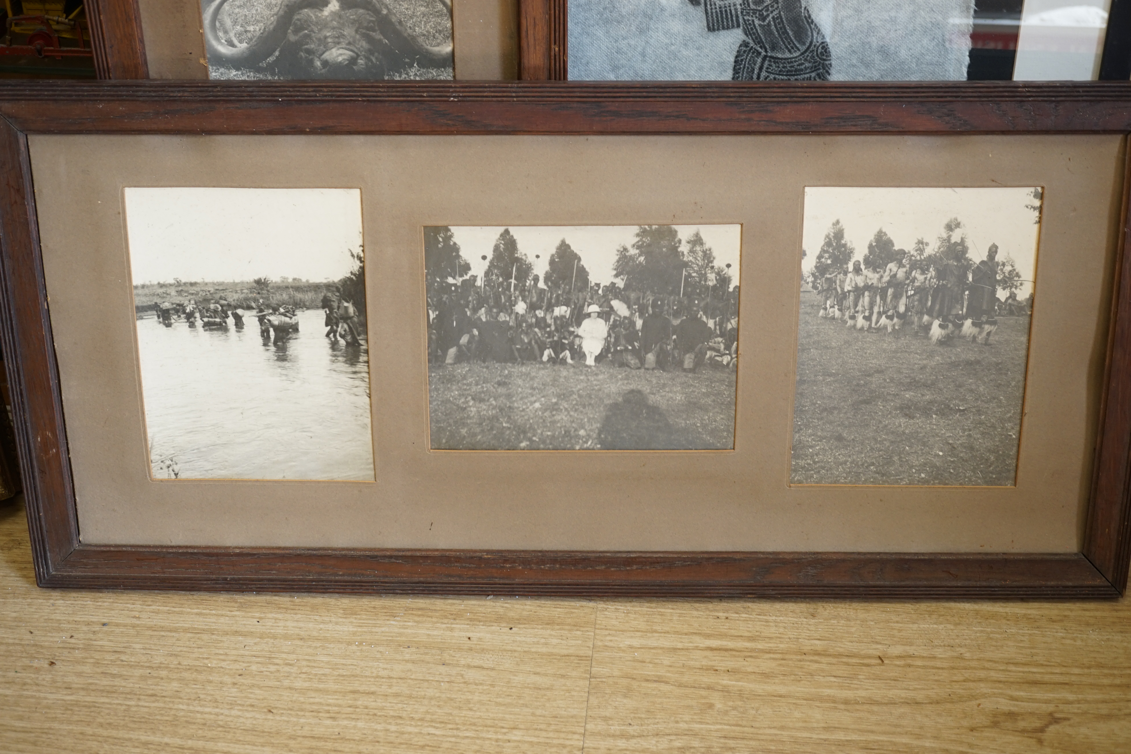 Three oak framed groups of black and white photographs of colonials in Africa, including Big game hunting and Zulu warriors, nine photographs in total, all approximately 21.5 x 16cm